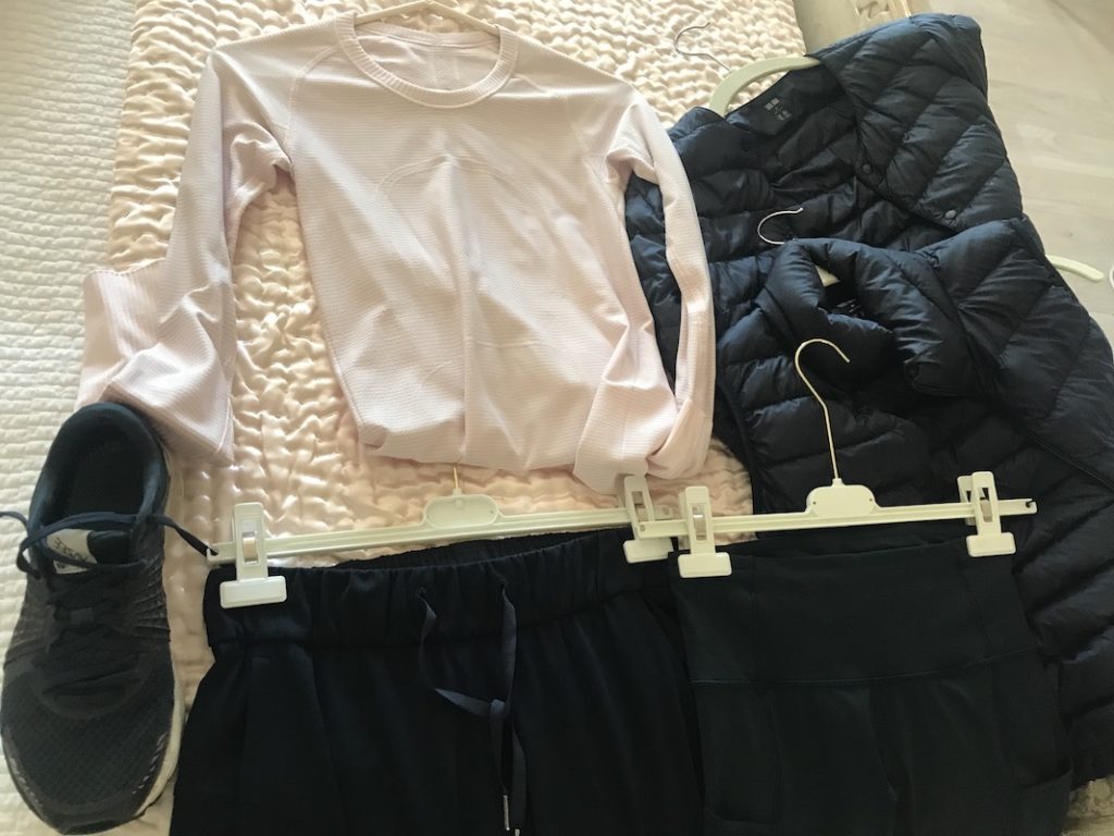 cream long sleeve shirt, black puffer jacket, black puffer vest, black athletic pants, black New Balance Sneakers