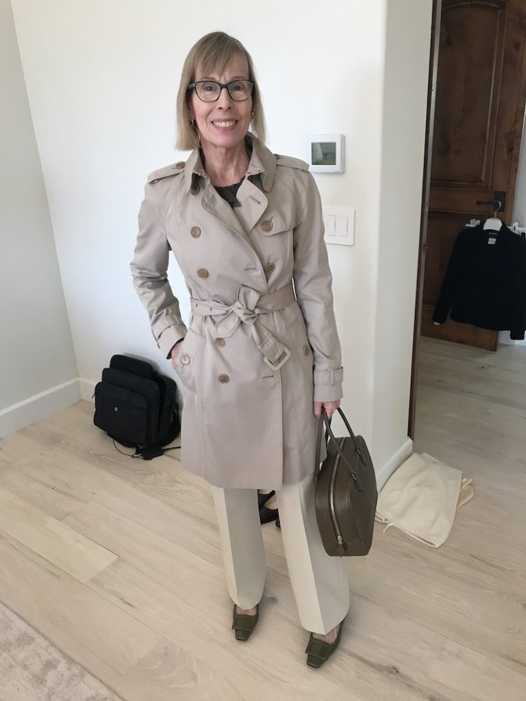 Bergdorf Goodman dark grey ruffled blouse, cream dress pants, Burberry beige trench coat, brown purse, olive green square toe flats